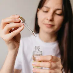 Kobieta aplikuje serum z niacynamidem, oczekując widocznych efektów poprawy kondycji skóry.