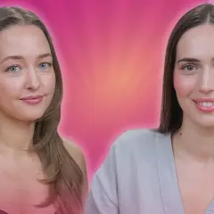 Dwie kobiety, jedna prezentuje różowy kamień do gua sha masażu, druga uśmiecha się.