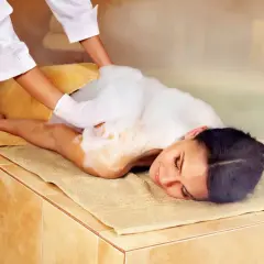 Kobieta w pianie podczas zabiegu hammam. To tradycyjna łaźnia parowa, która oczyszcza ciało i duszę.