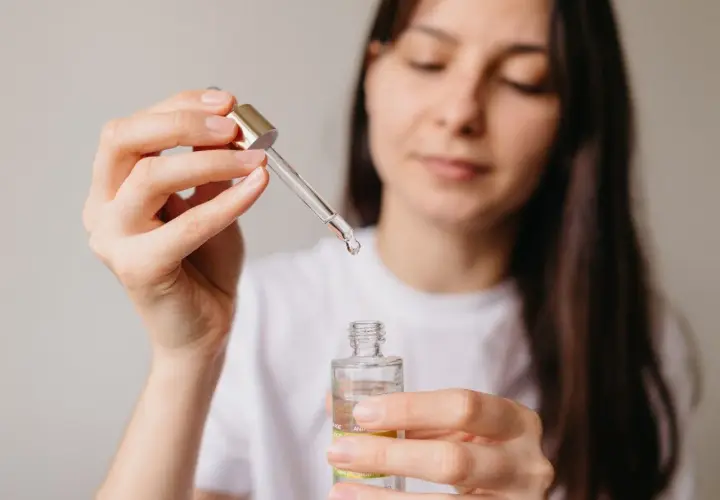 Kobieta aplikuje serum z niacynamidem, oczekując widocznych efektów poprawy kondycji skóry.