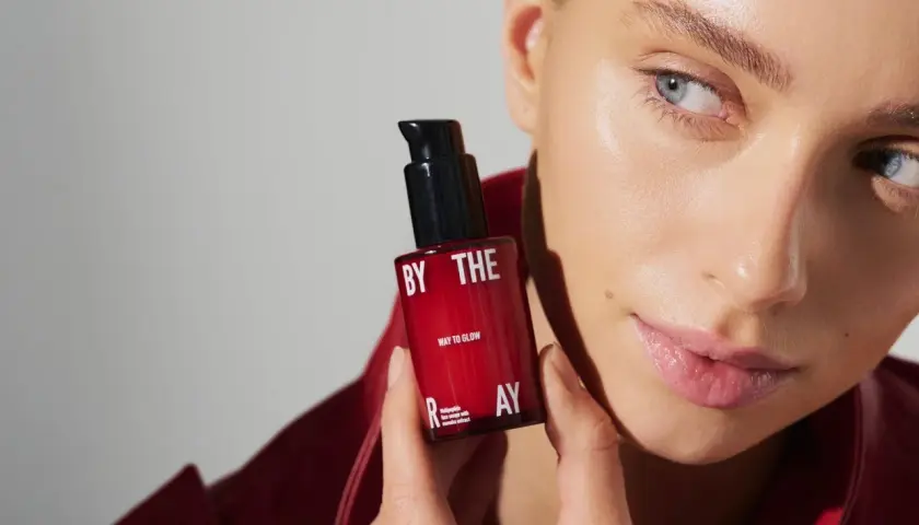 Kobieta z serum z peptydami w kosmetyce. Czerwona buteleczka z napisem "WAY TO GLOW" i "multipeptide face serum".