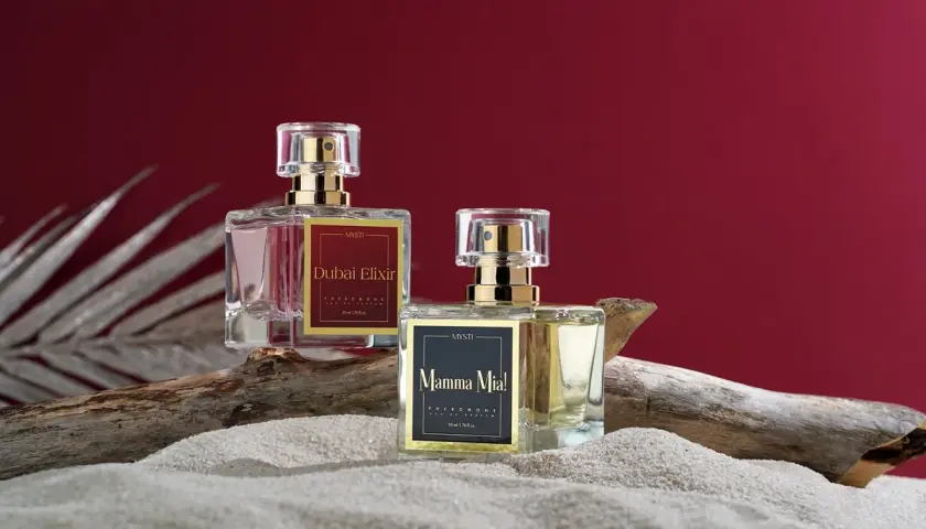 Dwa flakoniki perfum z feromonami na piasku. Czy perfumy z feromonami działają? Zobacz "Dubai Elixir" i "Mamma Mia!".