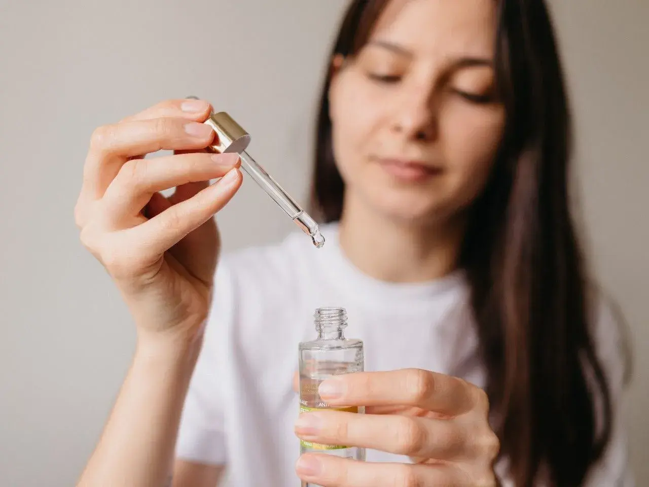 Kobieta aplikuje serum z niacynamidem, oczekując widocznych efektów poprawy kondycji skóry.