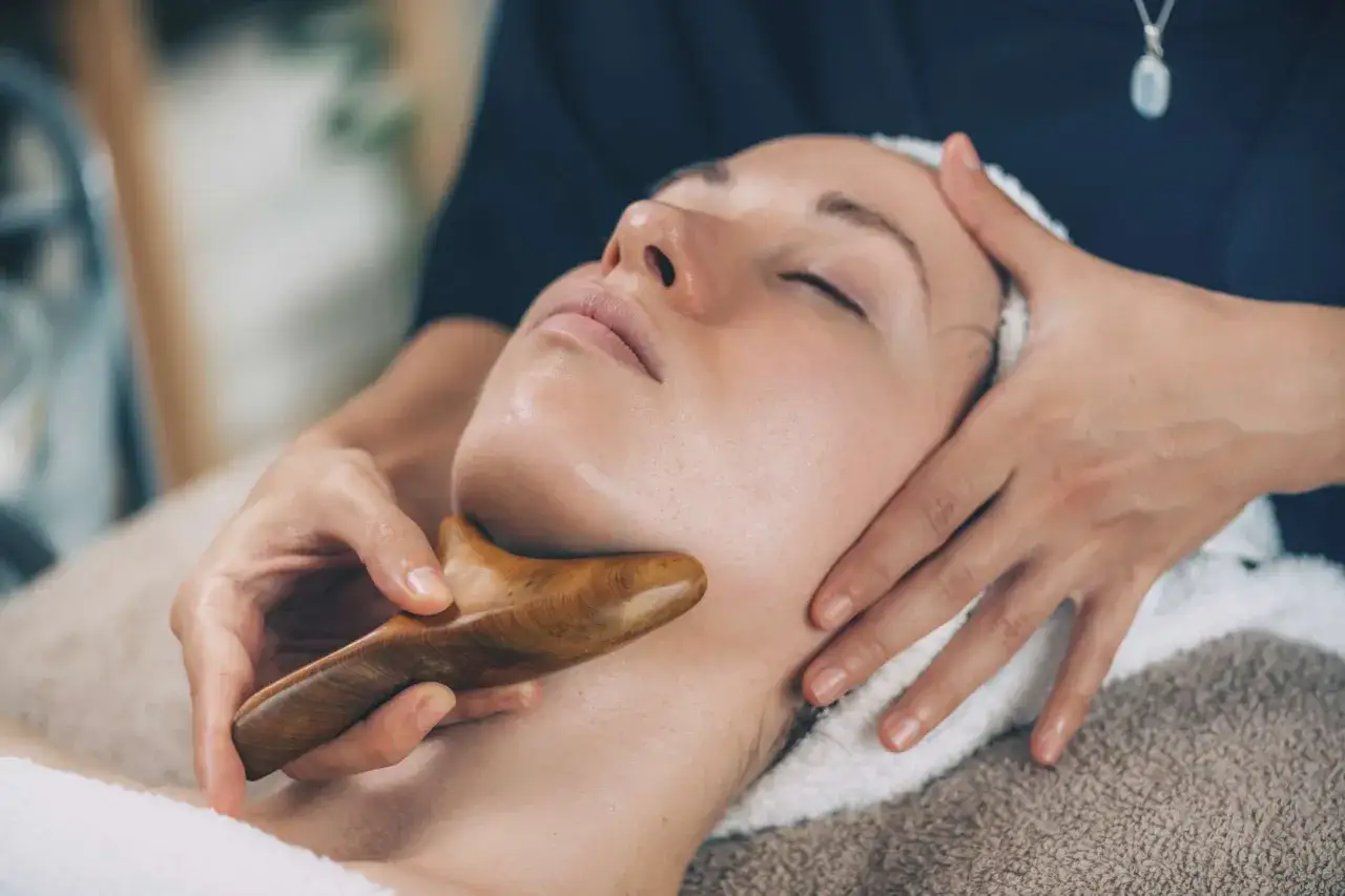 Masaż twarzy drewnianym narzędziem gua sha to naturalny sposób, jak poprawić wygląd twarzy, redukując napięcie i poprawiając krążenie.